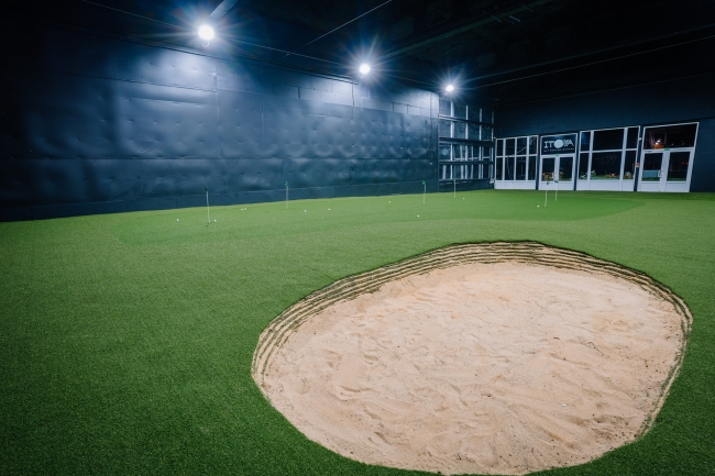 Iekštelpu golfa zāle ar smilšu bunkuru, ripināšanas bedrītēm un profesionālu apgaismojumu